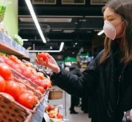Woman in a mask selecting produce