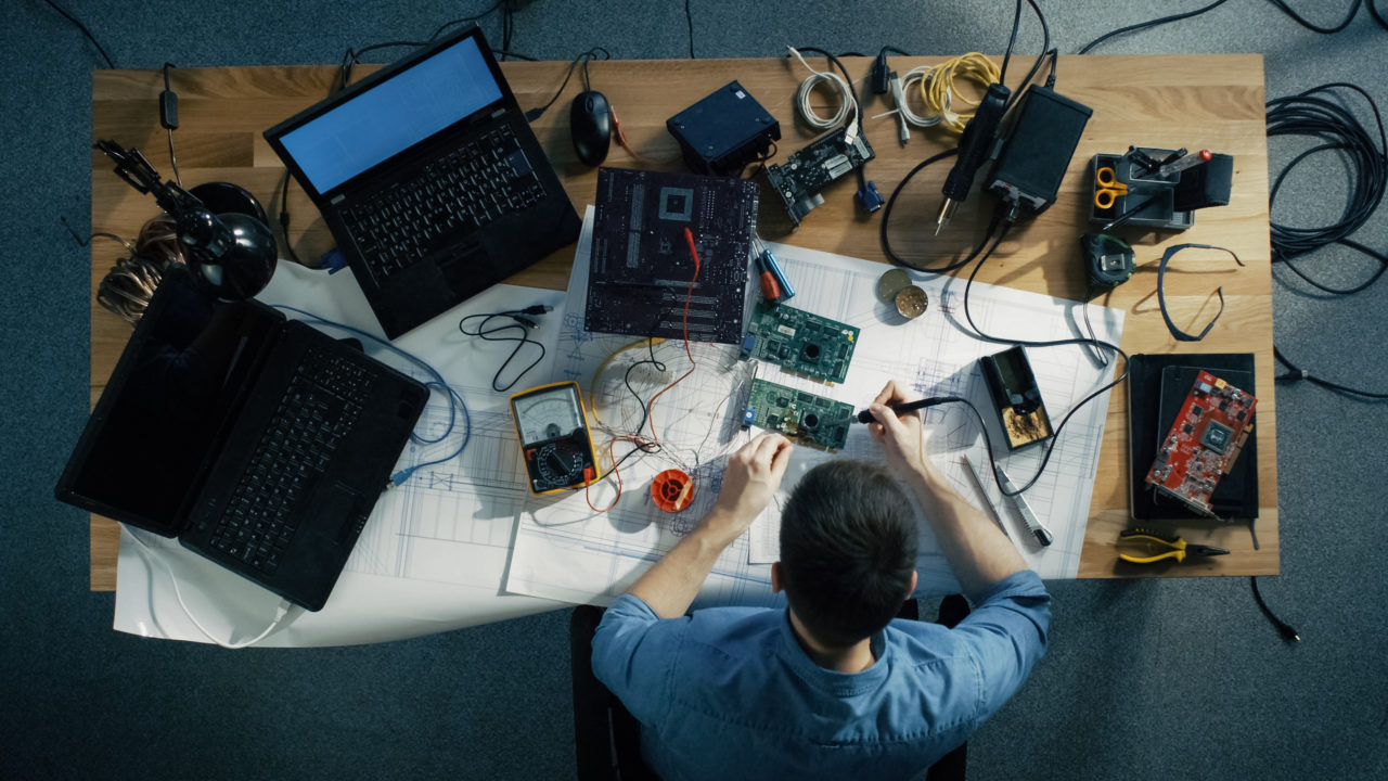 Overhead view of a man soldering a hard drive