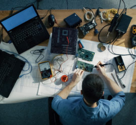 Overhead view of a man soldering a hard drive