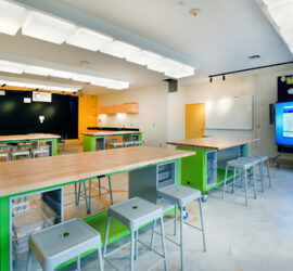 A science classroom at Passaic Academy for Science and Engineering with four lab tables and a smart board